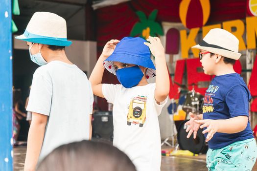 Latin boy enjoying the summer in a summer break activity dressed in comfortable clothes and a bucket hat and mask due to the coronavirus