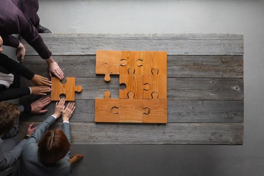 Business teamwork with wooden puzzle , last piece, problem is solved, cooperation unity concept