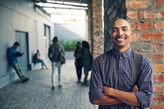 Portrait of a happy young man standing outdoors on campus.