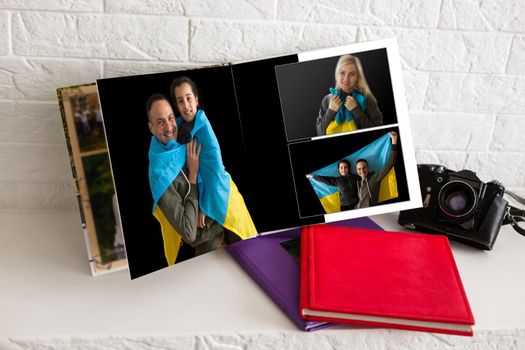 on white table open photobook from photo shoot of family with ukraine flag.