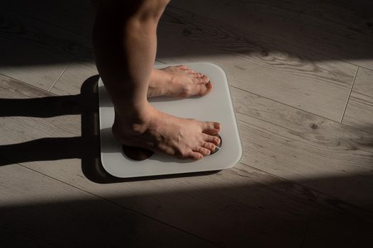 Close-up of female legs on electronic scales