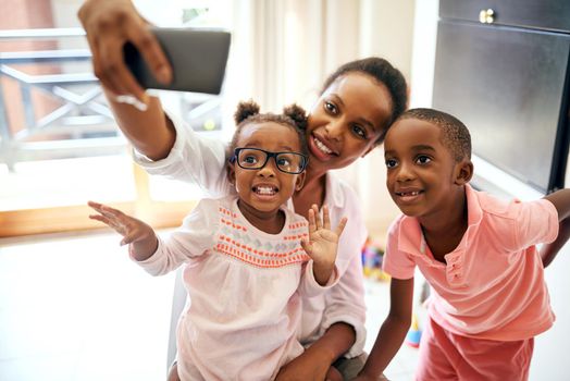 Cropped shot of an affectionate young family taking selfies at home.