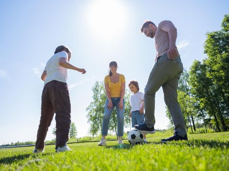 Active family with two children play soccer in their leisure time