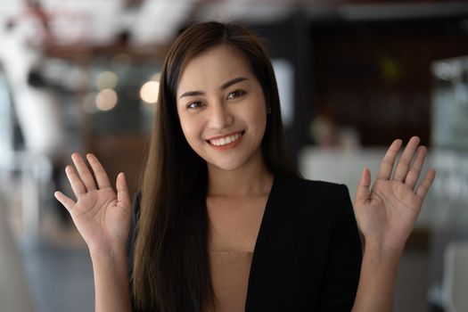 Smiling asian woman waving hand looking at camera, she making video blog or call at home, happy friendly vlogger