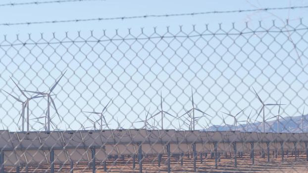 Windmills turbine rotating, wind farm or power plant, alternative green renewable energy generators, industrial field in California, Mojave desert, Tehachapi, USA. Electricity generation on windfarm.
