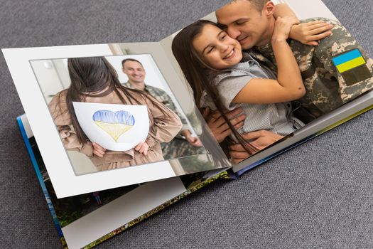 Family photos archive saved in brightly designed photo book; bright summer memories placed in the photobook. family with flag of ukraine.