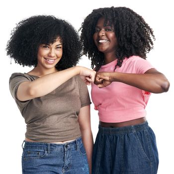 Studio shot of two young women bumping fists against a white background.