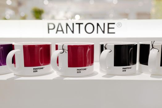 Milan, Italy - December 15, 2020: Pantone mug on a white shelf. Fromt view