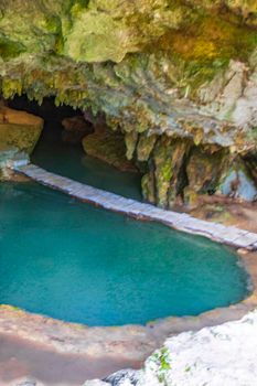 Amazing blue turquoise water and limestone cave sinkhole cenote at Santuario de los guerreros in Puerto Aventuras Quintana Roo Mexico.