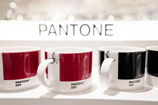 Milan, Italy - December 15, 2020: Pantone mug on a white shelf. Fromt view