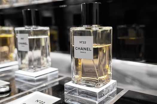 Female perfume Chanel No. 22 bottle closeup in store showcase. Perspective view of french Chanel perfume collection. Product from Coco Chanel in Rinascente. Milan, Italy - December 15, 2020.