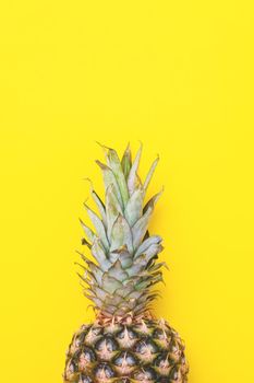 Pineapple on a yellow background. Creative summer greeting concept, vertical photo. Blog template