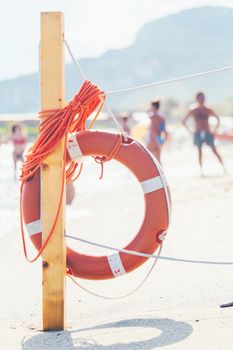 Life saver rescue ring with rope on the beach in case of emergency. Life saving lifeguard buoy. Italy, Finale ligure - August 23, 2020