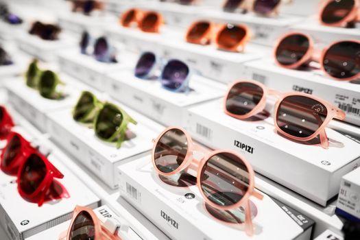 Sunglasses stand on the shop shelf. Sun glasses in Rinascente, collection of high-end stores with Italian and international brands in fashion, accessories, design. Milan, Italy - December 15, 2020