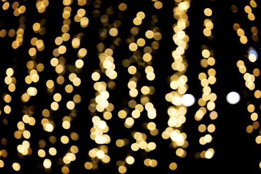 Defocused lights of christmas garlands, golden bokeh light. Abstract background.