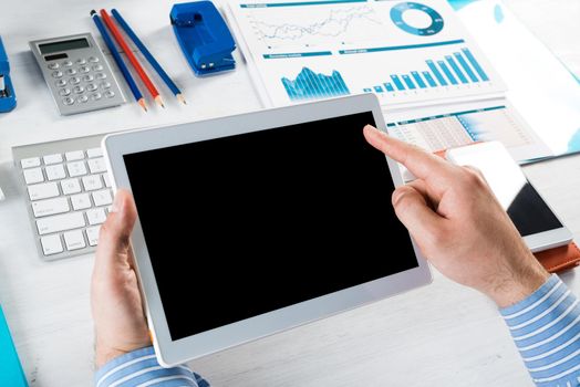 close-up of men's hands with a computer tablet. Businessman works in the office