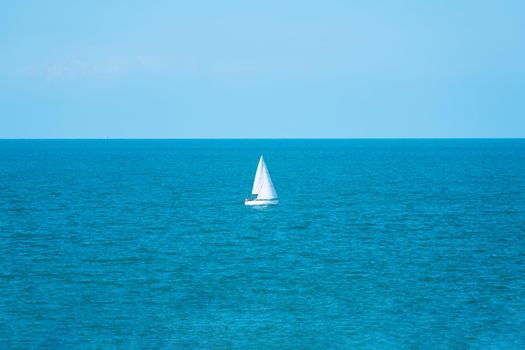 Sailboat, yawl, sailing in an open sea. Coast of Rimini, Italy. Sport, cruise, recreation, leisure activity. Sloop rigged yacht sailing in a Mediterranean sea on a clear sunny day