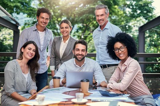 Cropped portrait of a group of business colleagues having a meeting outdoors at a cafe.