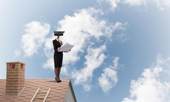 Faceless businesswoman with camera zoom instead of head standing on house roof