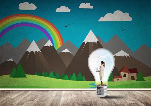 Businesswoman inside light bulb in room against nature drawn concept