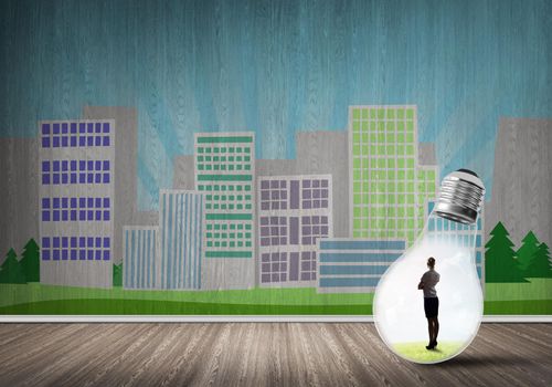 Businesswoman inside light bulb against city drawn concept