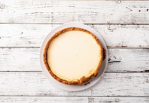Tasty homemade cheesecake on white wooden table with copy space