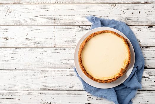 Tasty homemade cheesecake on white wooden table with copy space