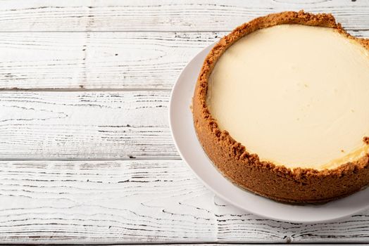 Tasty homemade cheesecake on white wooden table with copy space
