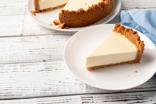 Tasty homemade cheesecake on white wooden table with copy space