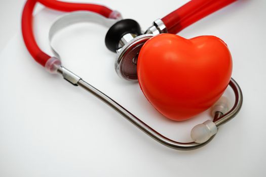 Stethoscope and red heart on white background, heart health, health insurance concept.