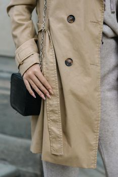 Portrait of fashionable women in beige sports suit and trench coat posing. street look fashion