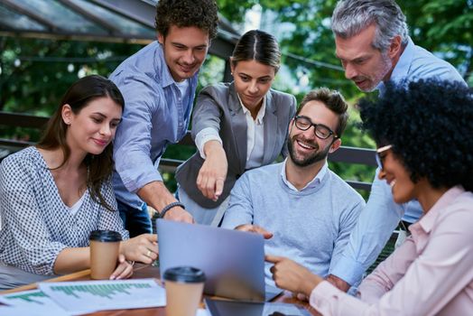 Cropped shot of a group of business colleagues having a meeting outdoors at a cafe.