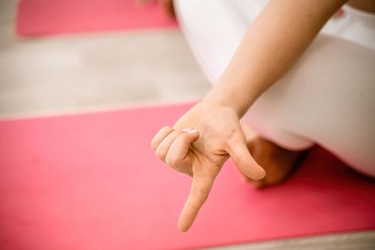 Girl does yoga. Young woman practices asanas on a beige one-ton background