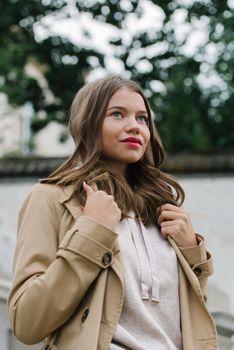 Portrait of fashionable women in beige sports suit and trench coat posing. street look fashion