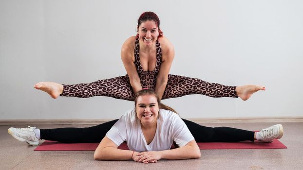Caucasian woman doing a handstand on her friend. Pair acrobatics