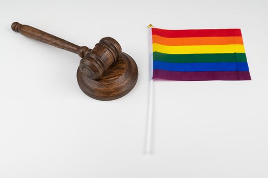 Judge gavel and hand lgbt flag on white background