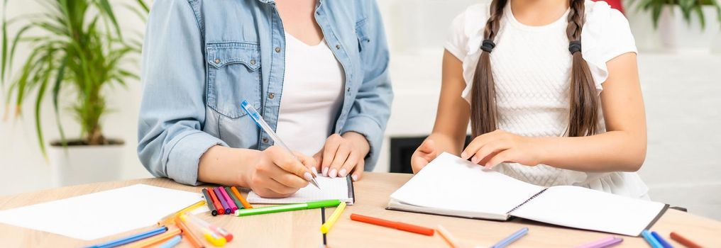 Mother and daughter spending time together at home drawing.