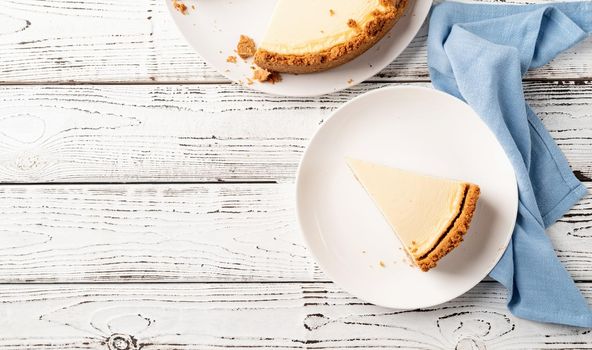 Tasty homemade cheesecake on white wooden table with copy space