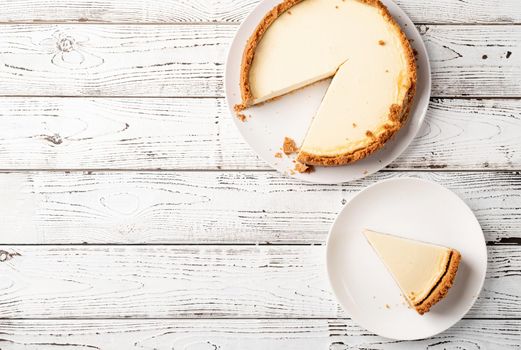 Tasty homemade cheesecake on white wooden table with copy space