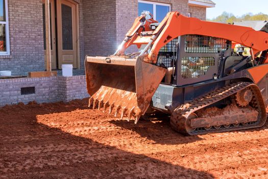 Moving soil with landscaping works equipment a excavationon the construction site in earth