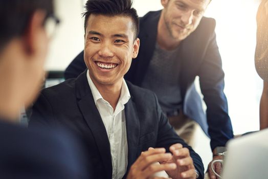 Shot of a group of coworkers having a discussion in a boardroom.