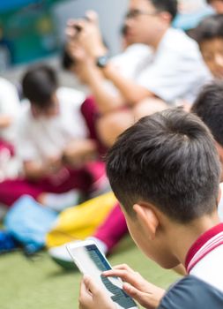 BANGKOK THAILAND - April 19,2018 Many Serious children playing on smartphone, Children playing on smartphone during the brake time in school