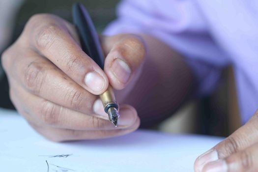 Close up of man hand writing a letter with fountain pen.