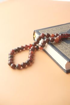 Holy book Quran and rosary on table, close up