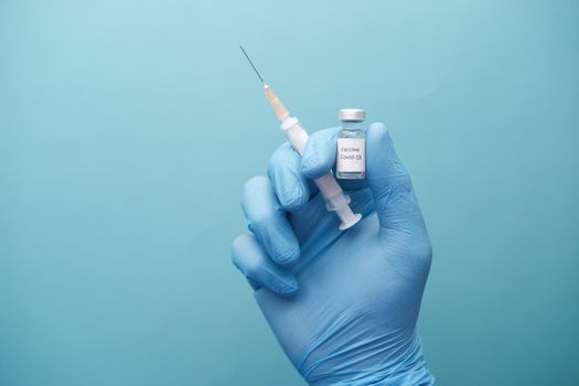 doctor hand in gloves holding coronavirus vaccine, close u.
