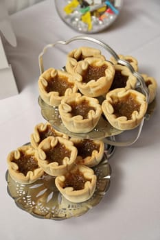 Butter Tarts Buttertarts on Silver Stand on White Dessert Table. High quality photo
