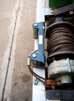 Old sling cable of electric winch in front of 4x4 car