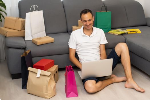 Young man buying music on internet with laptop.