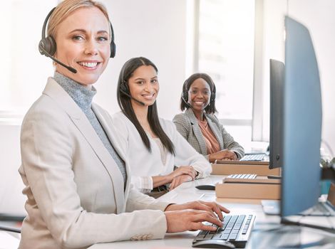 Cropped portrait of an attractive mature female call center agent wearing a headset while working in the office with her coworkers.