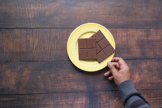 hand pick dark chocolate on a plate .